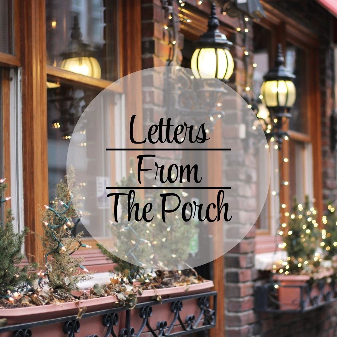 Cozy porch with festive lights and plants.