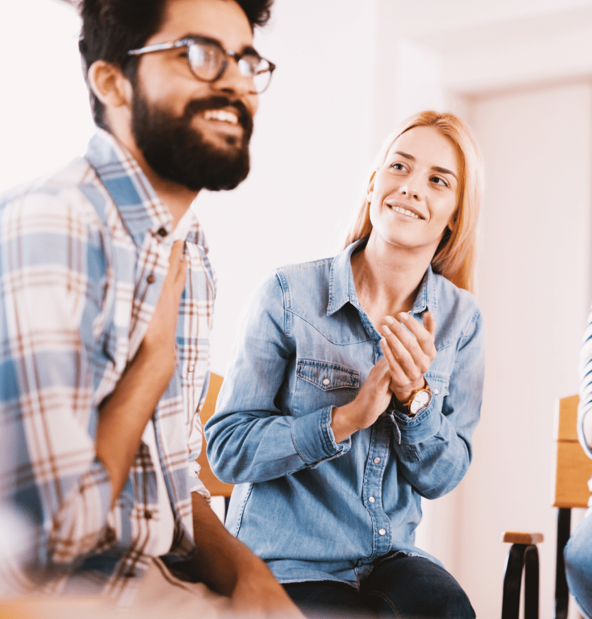 Woman applauding man during group discussion